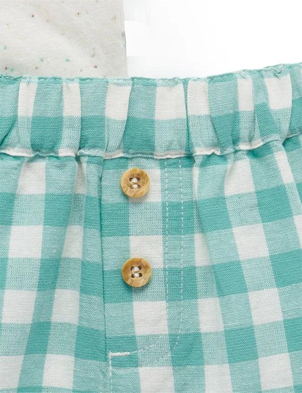 Close-up of turquoise and white gingham baby shorts waistband with two wooden buttons