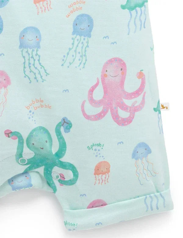 Close-up of baby romper fabric with colorful octopus and jellyfish print on light blue background