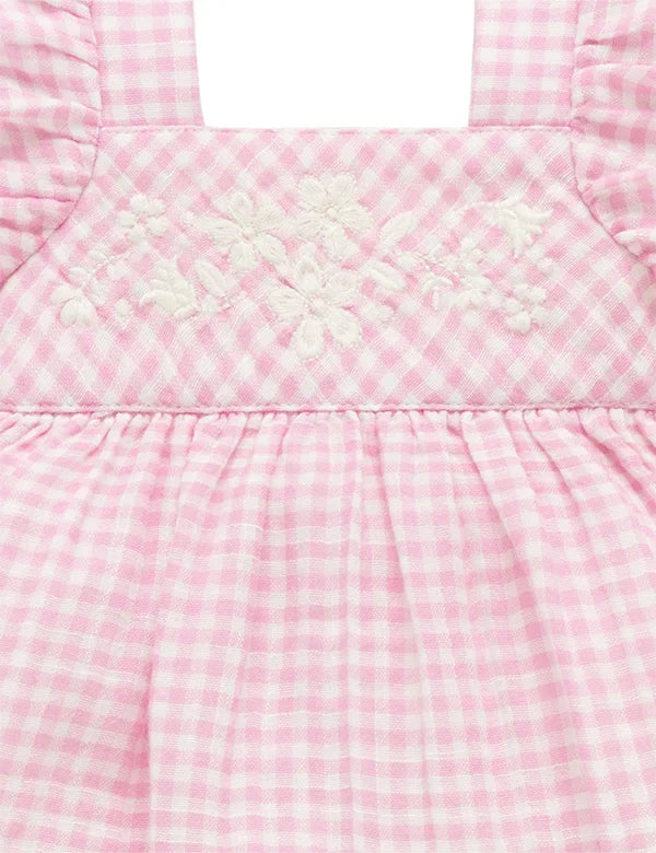 Pink gingham baby dress with white floral embroidery on skirt hem detail