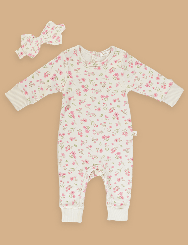 A charming Oh My Baby organic cotton baby romper with a delicate pink floral print, paired with a matching bow headband. Shop adorable baby outfits online in India.