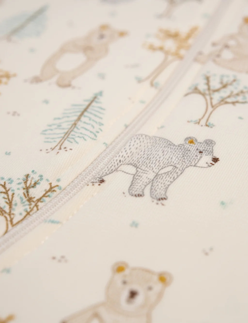 Close-up of a fabric with bear illustrations and nature-themed patterns.