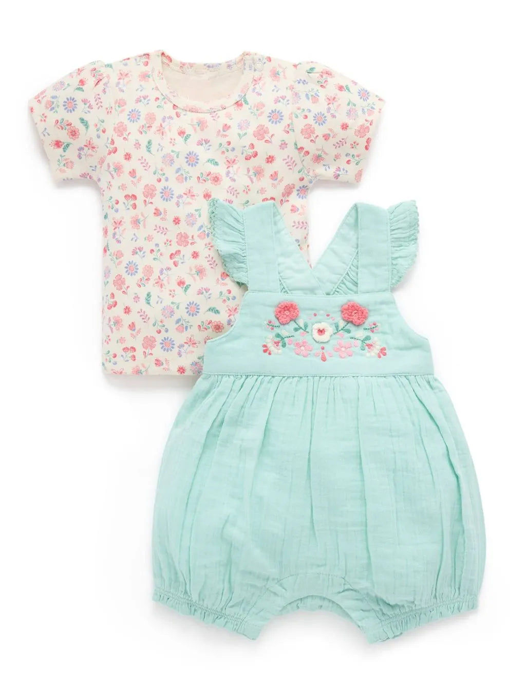 Flatlay of an organic cotton short-sleeve floral print top paired with a mint green embroidered onesie featuring ruffled straps.