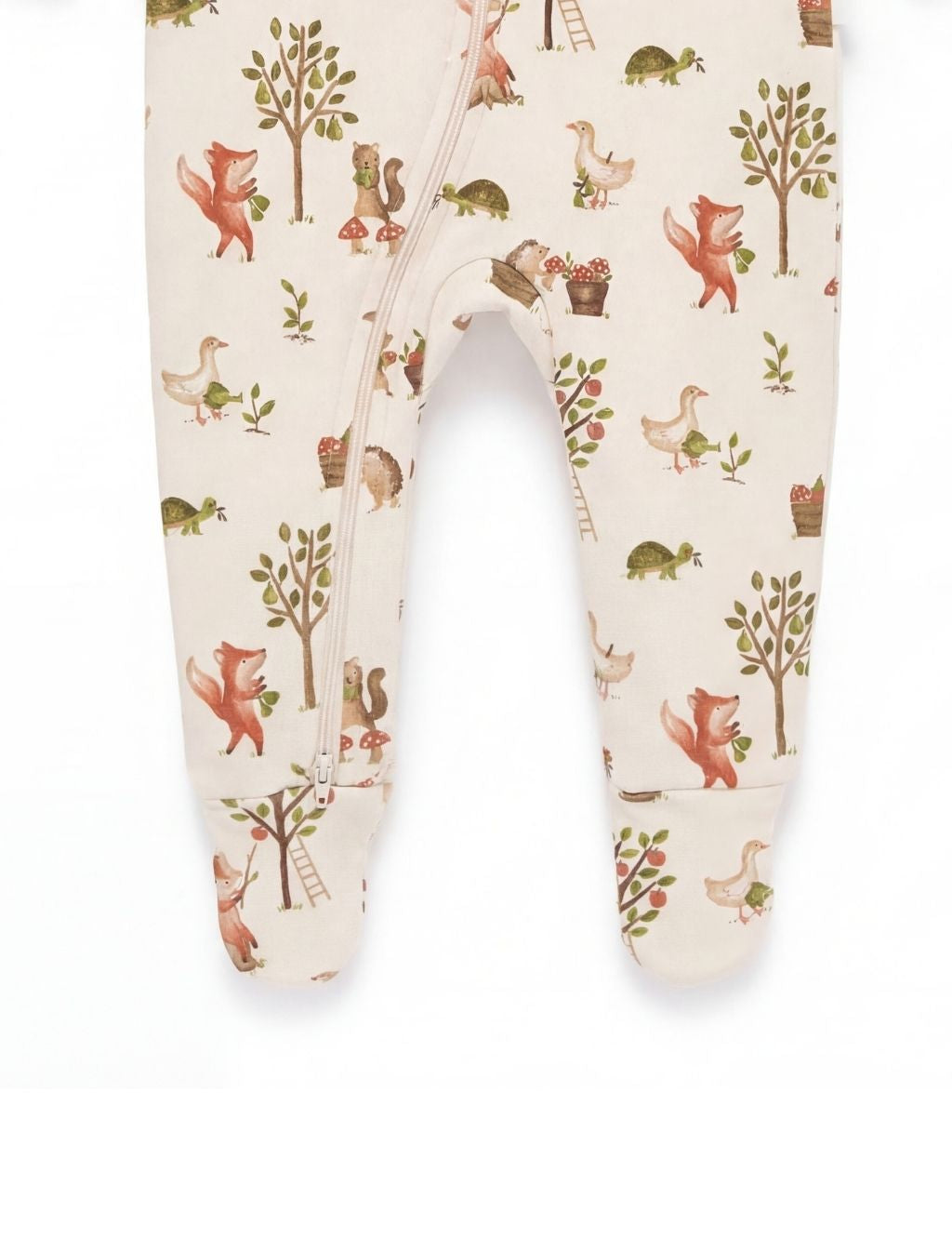 Leg and specialized closed foot detail of the cream organic cotton footed baby romper.