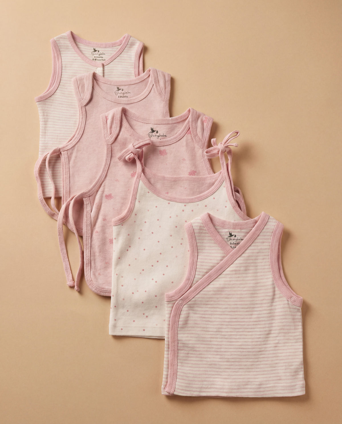 Stack of organic cotton pink baby tops, tie-side shirts, and striped side-snap shirts
