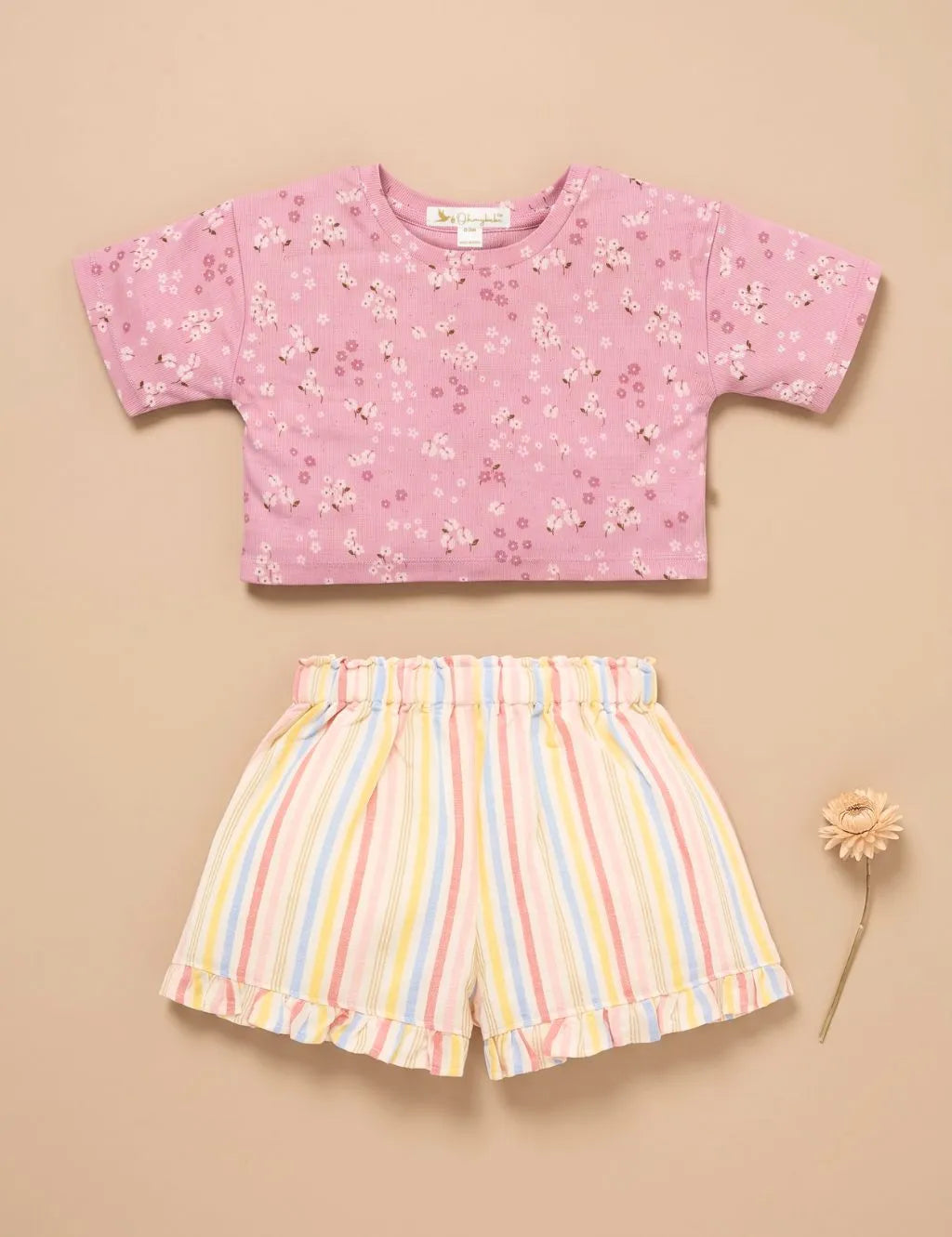 Flatlay of an organic cotton pink floral t-shirt and pastel striped shorts with a decorative flower.