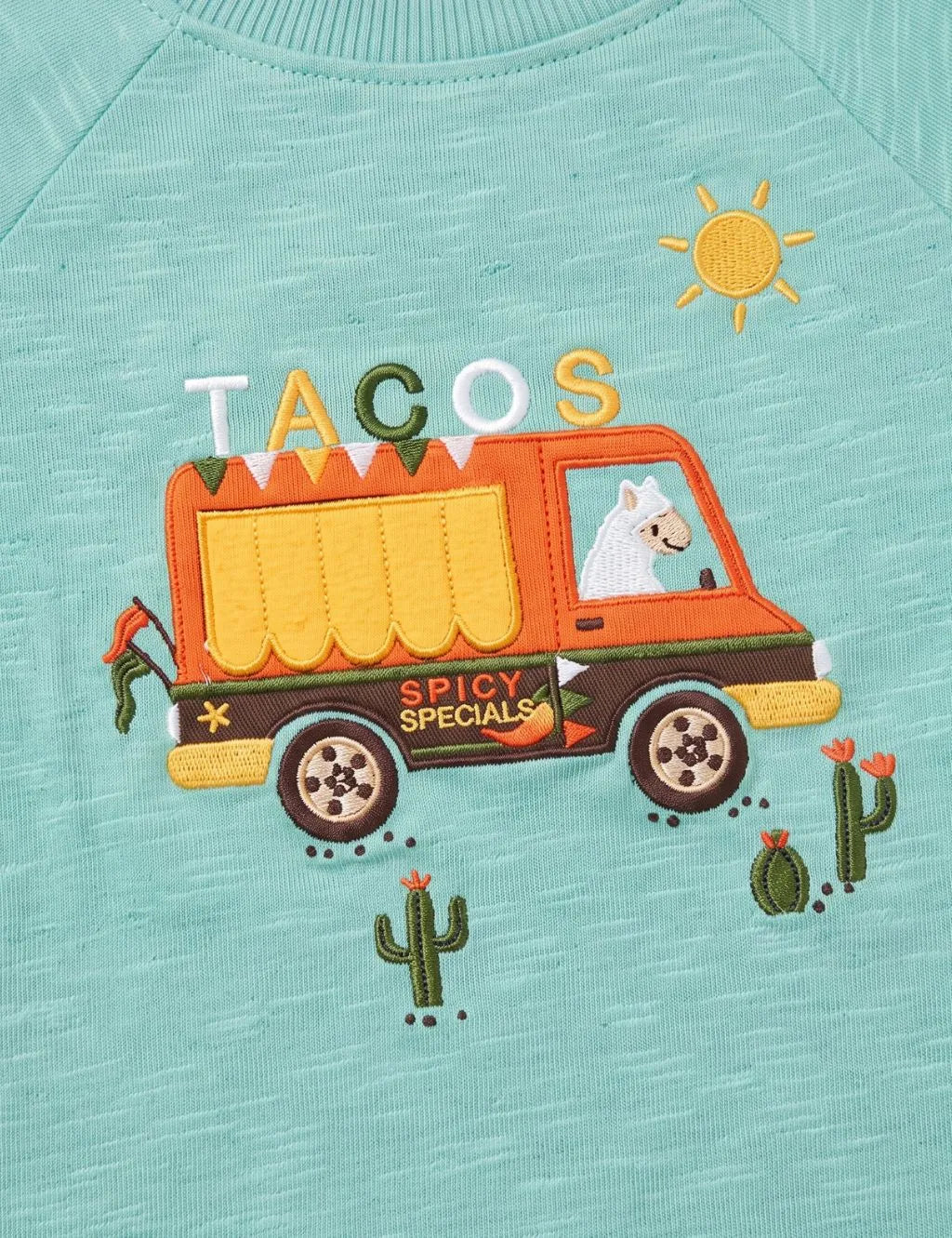 Close-up of the embroidered taco food truck graphic and cactus details on the organic cotton top.