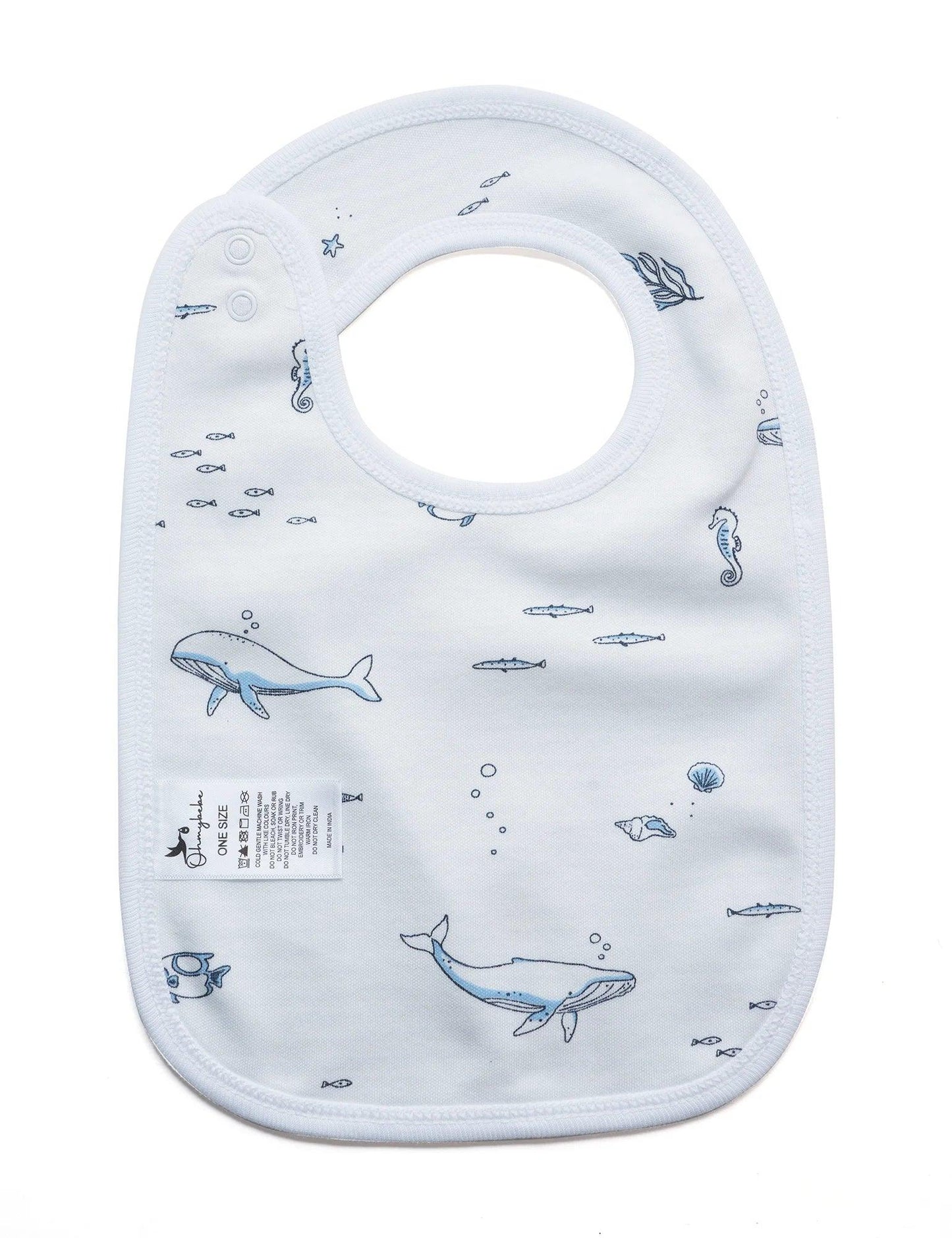 White organic cotton baby bib with blue ocean animal prints including whales, seahorses, fish, and shells