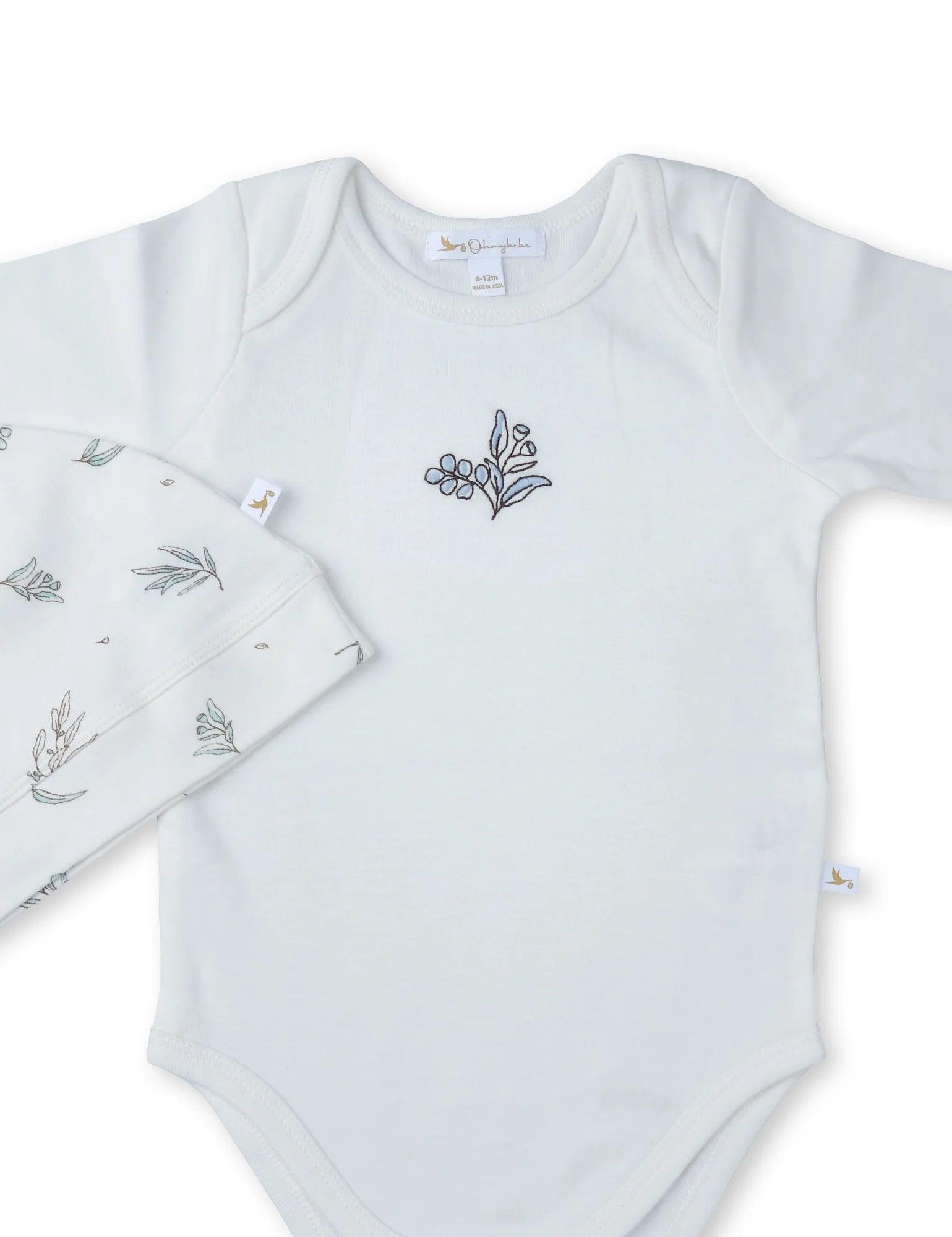 White organic cotton baby bodysuit with blue floral embroidery and matching hat with leaf print