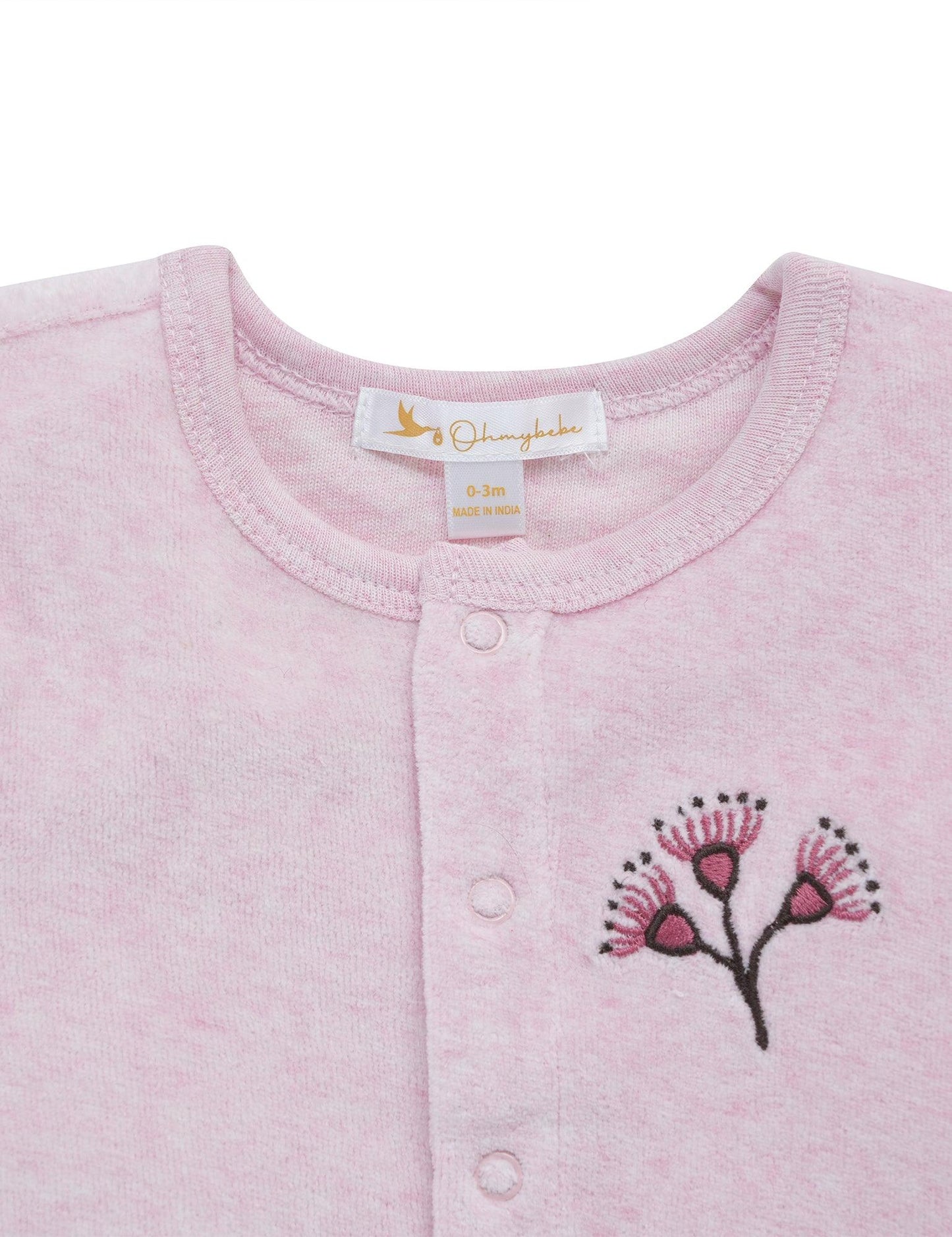 Close-up of pink organic cotton baby cardigan with hand-embroidered floral design and snap buttons