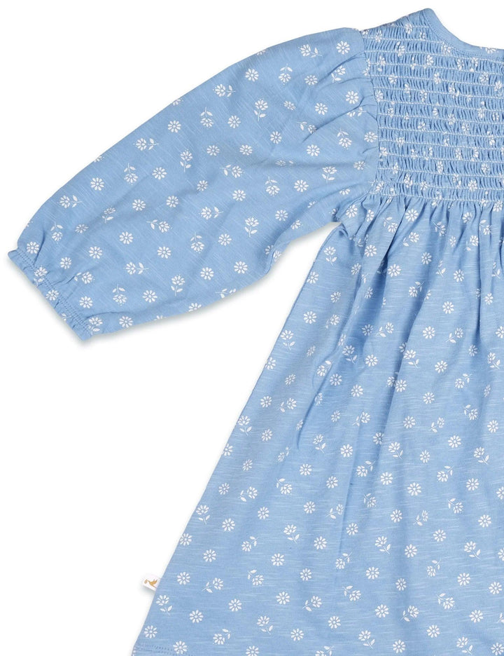 Detail of the long sleeve and gentle gathering at the cuff of the light blue 100% organic cotton baby dress with a ditsy print. See organic baby wear India.