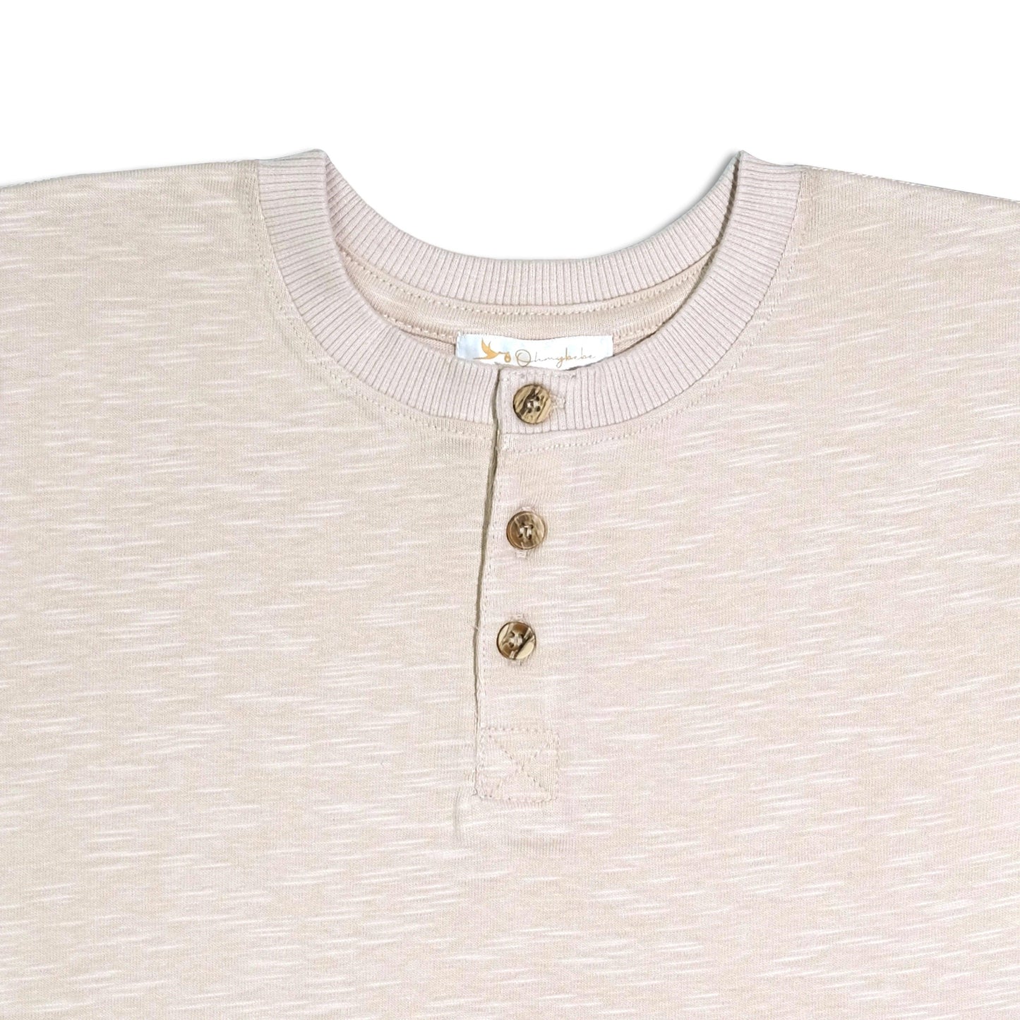 Close-up of beige organic cotton baby henley tee with ribbed collar and three wooden buttons