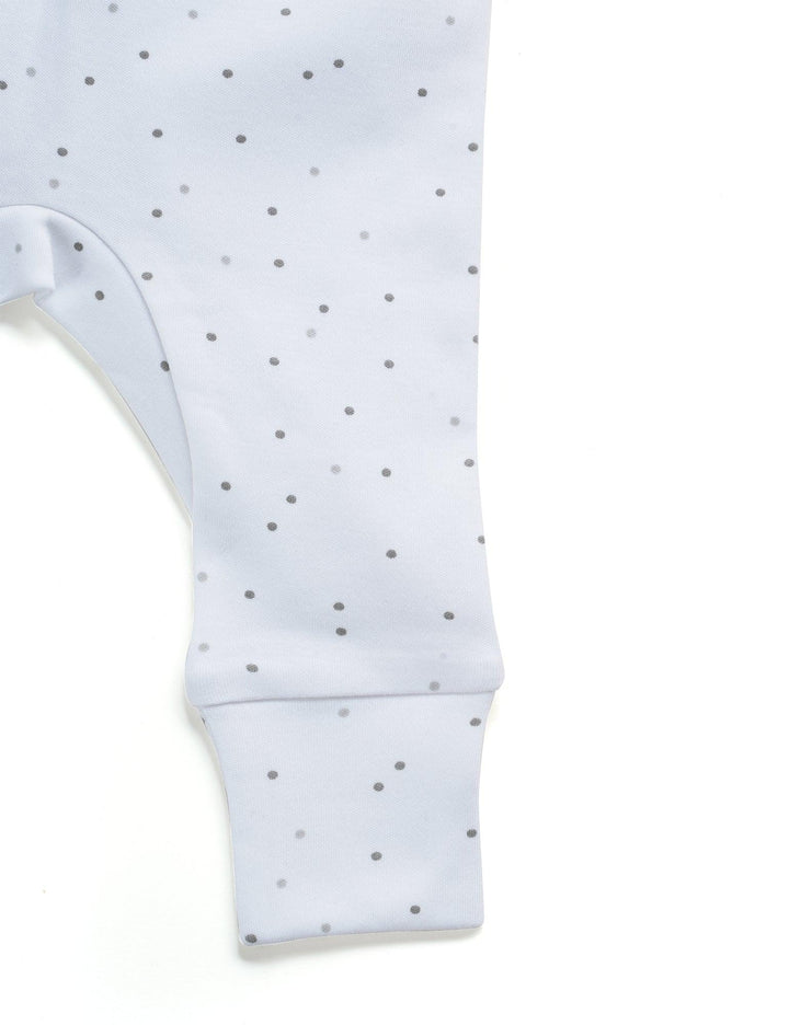 Close-up of the white organic cotton baby leggings with a subtle pattern of small grey dots and a comfortable cuffed ankle. See soft baby clothing India.