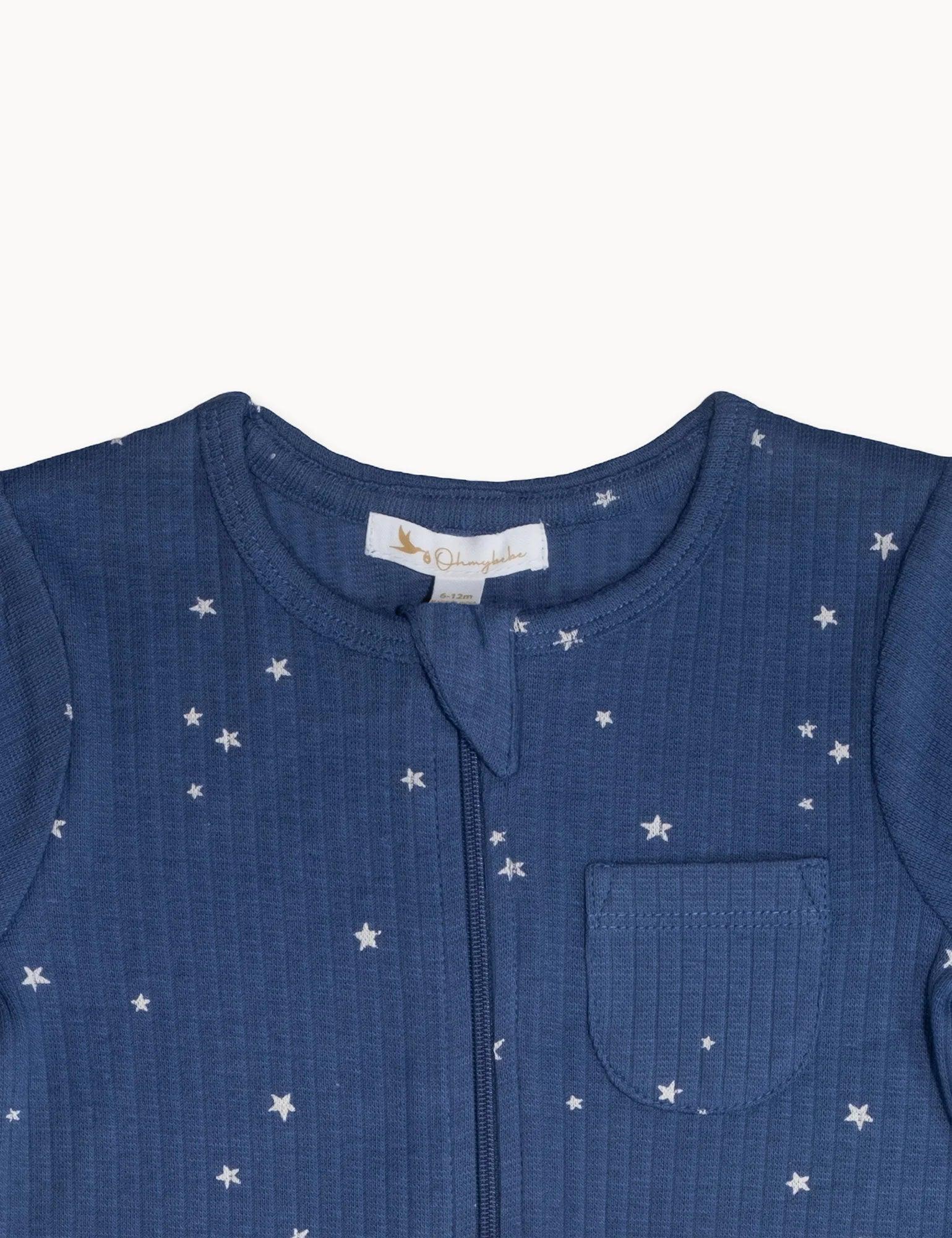 Close-up of blue organic cotton baby romper with white star pattern and front pocket