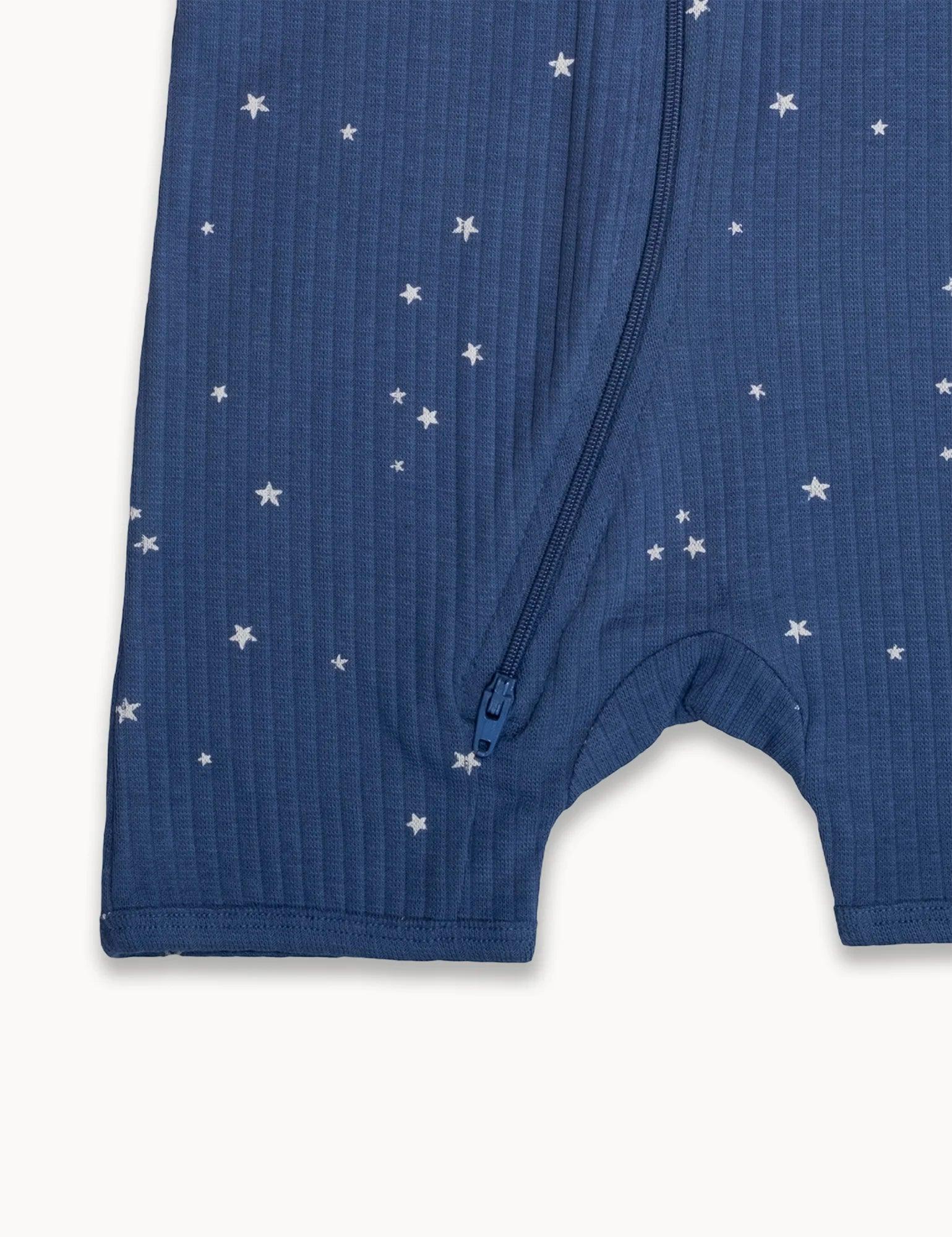 Blue organic cotton baby romper with white star print and front zipper detail