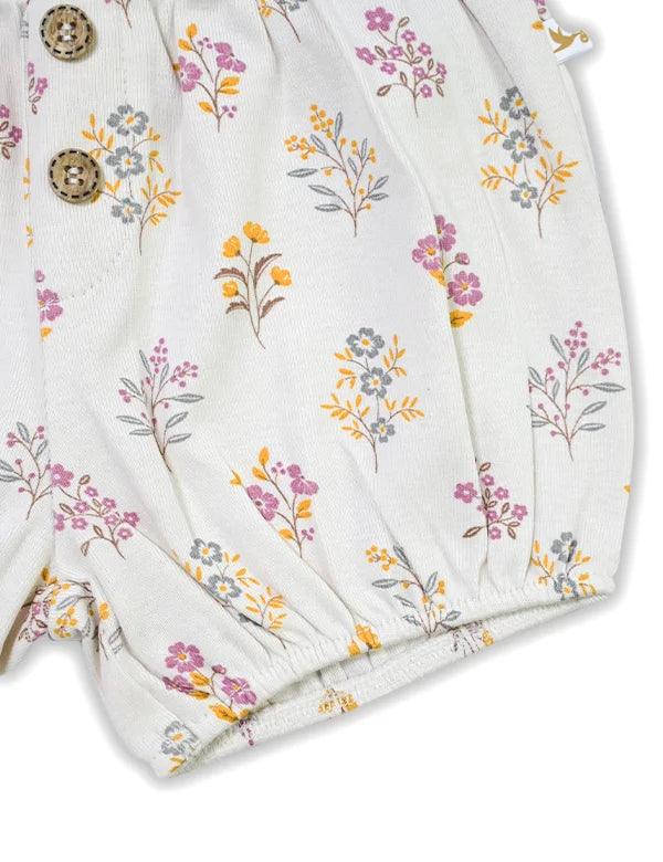 Organic cotton baby shorts with floral print and wooden button detail on white fabric