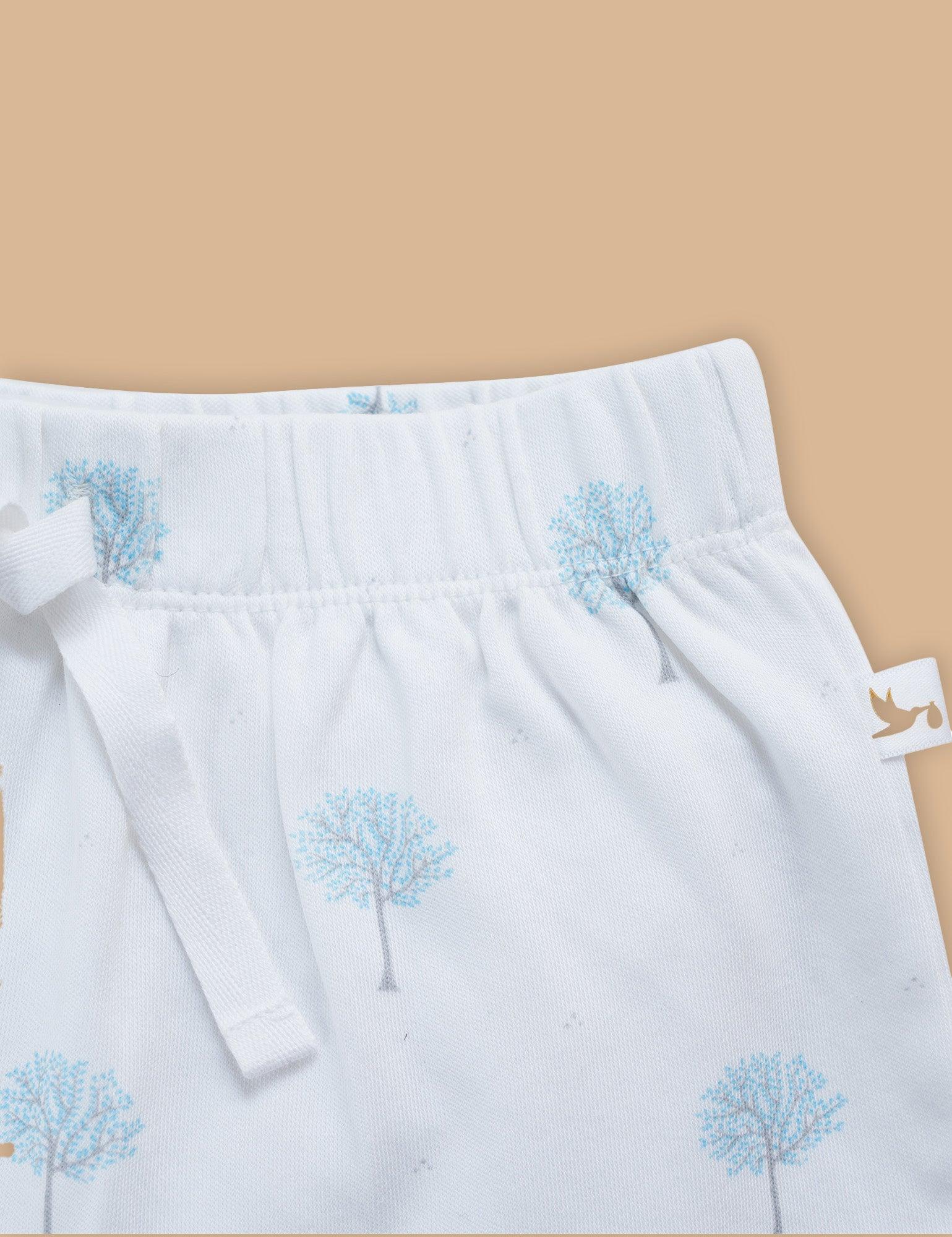 Close-up of organic cotton baby shorts with blue tree print and elastic waistband detail
