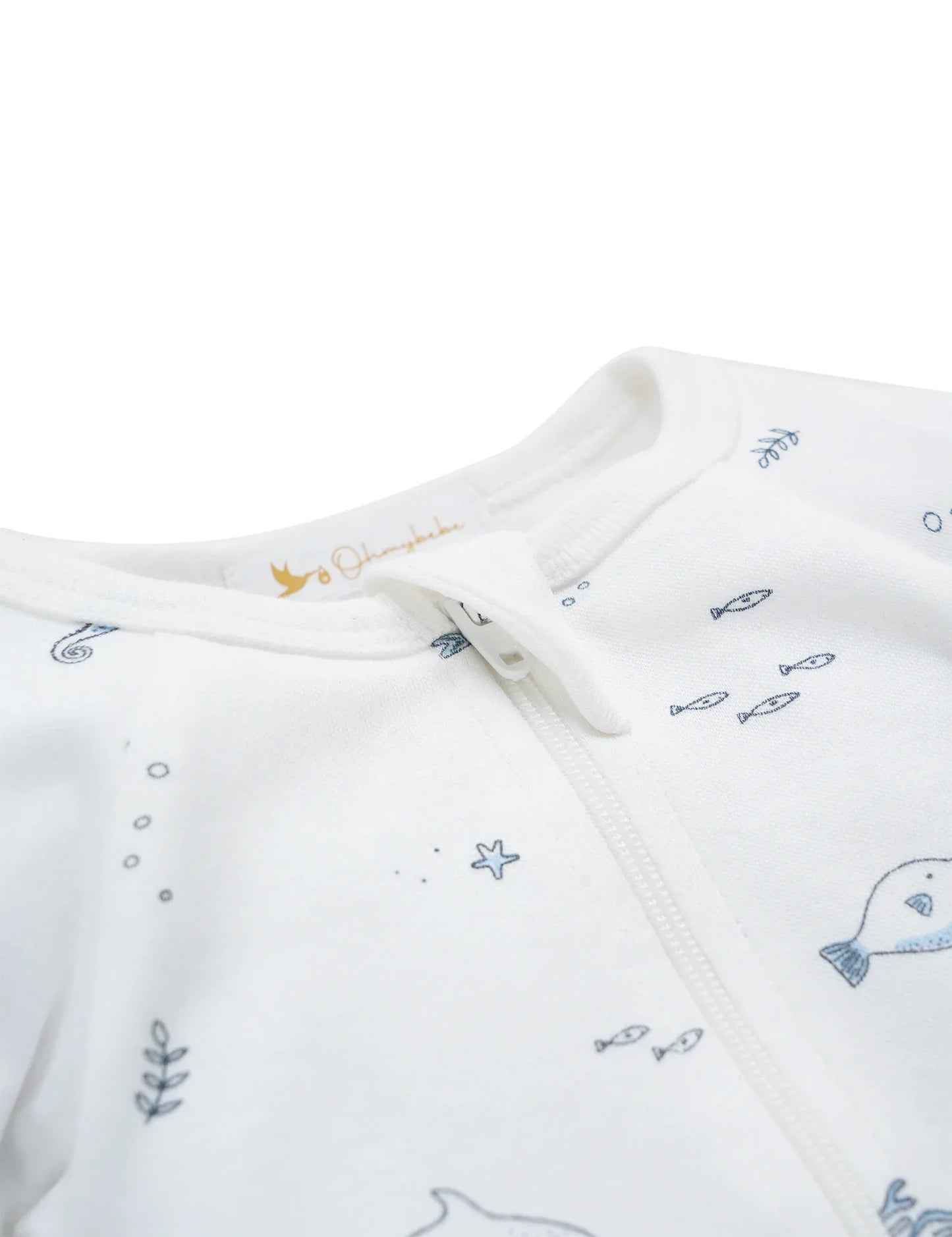 Close-up of white organic cotton baby sleepsuit with blue nautical fish and ocean print, front zipper