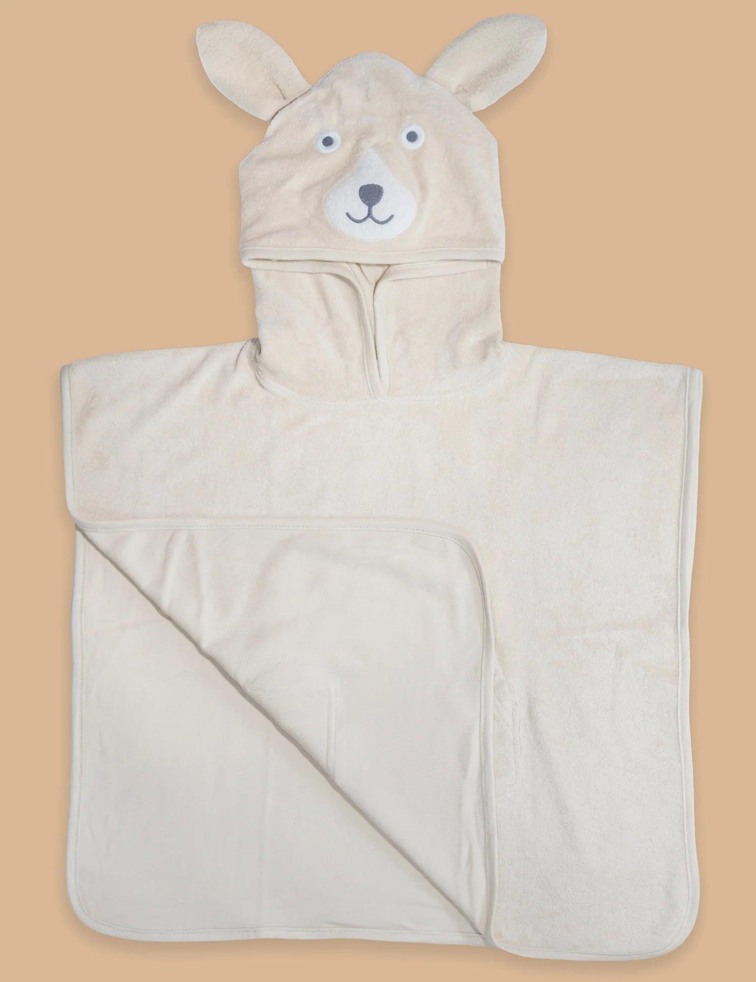 Cream organic cotton baby towel poncho with bear face hood and ears flatlay on beige background