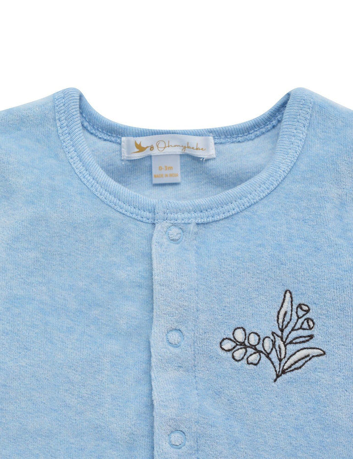 Close-up of the soft blue organic cotton baby cardigan showing the delicate olive branch embroidery on the chest. See unique baby wear India.