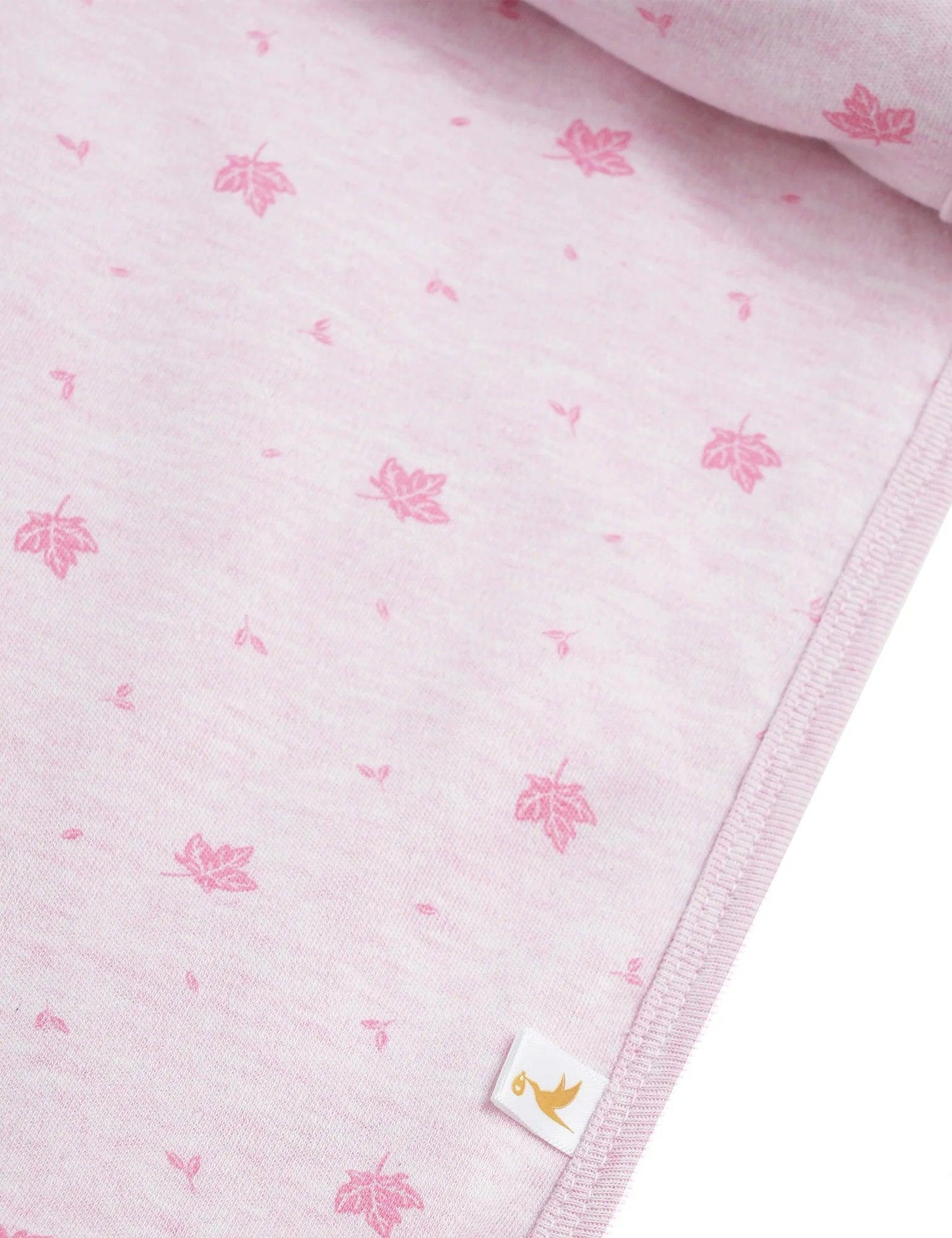 Soft pink organic cotton muslin swaddle with maple leaf print and stitched edge detail