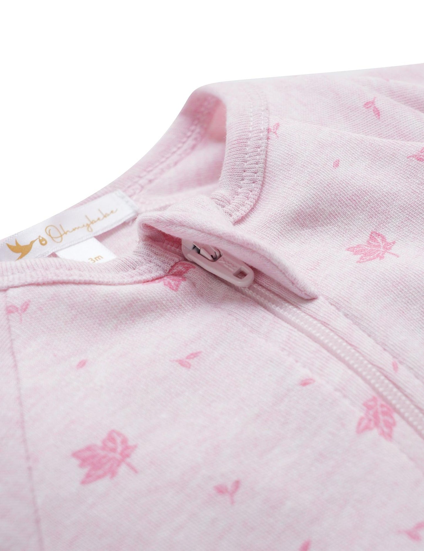 Close-up of pink organic cotton baby garment with leaf pattern and zipper neck detail