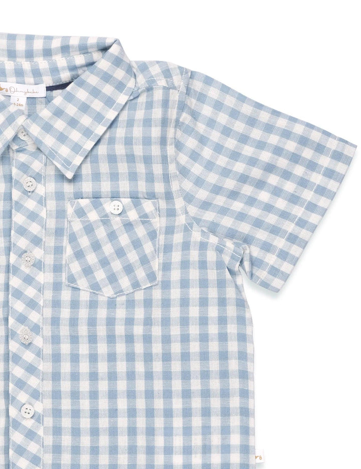  Close-up of the light blue and white gingham organic cotton shirt showing the fabric texture, buttons, and chest pocket. See organic baby tops India.