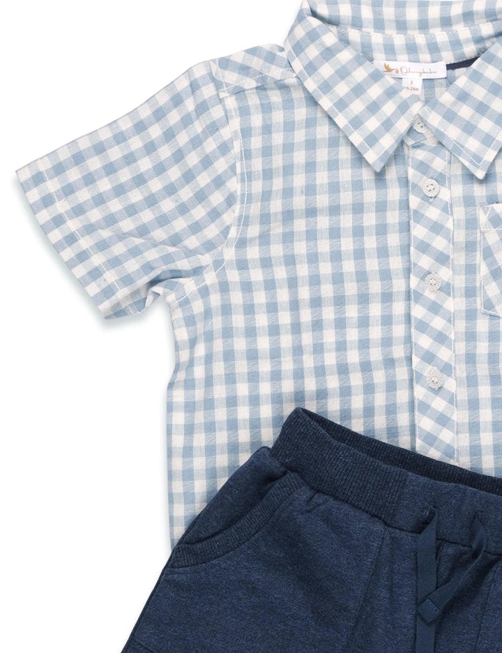 Close-up showing the fabric texture of the light blue and white gingham organic cotton shirt paired with the navy blue organic cotton shorts. See organic baby wear India.