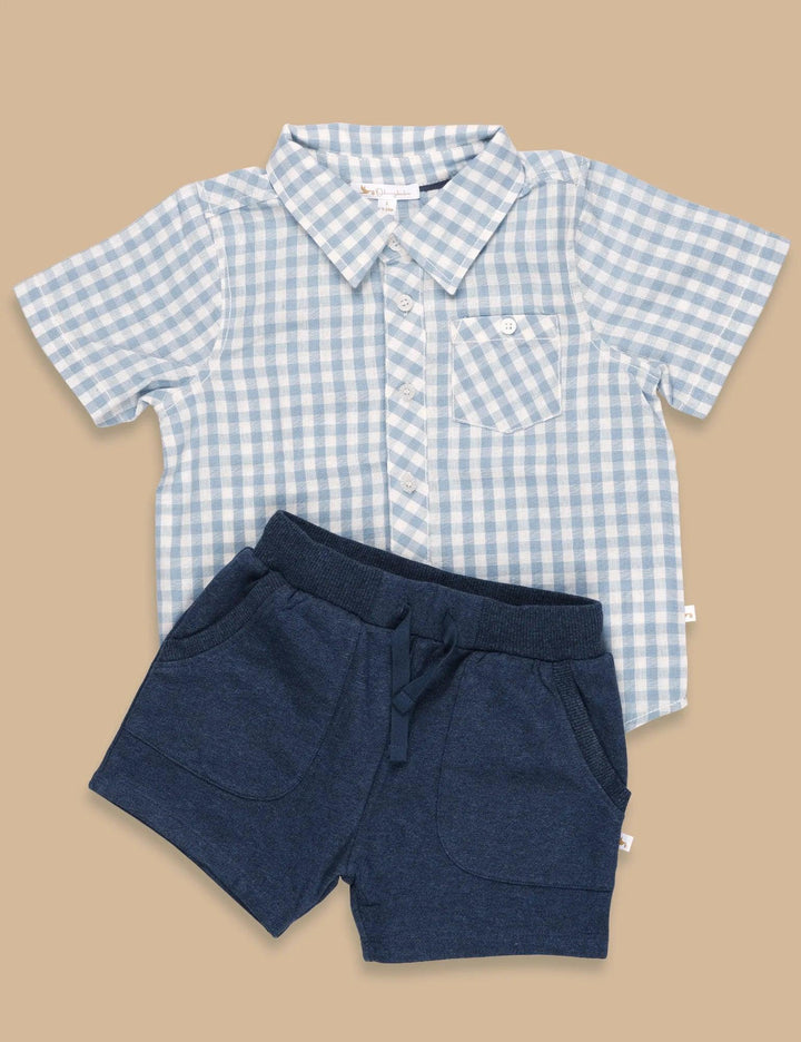  Set of a light blue and white gingham organic cotton short-sleeve collared shirt with buttons, and comfortable navy blue organic cotton shorts. Buy baby clothing sets India.