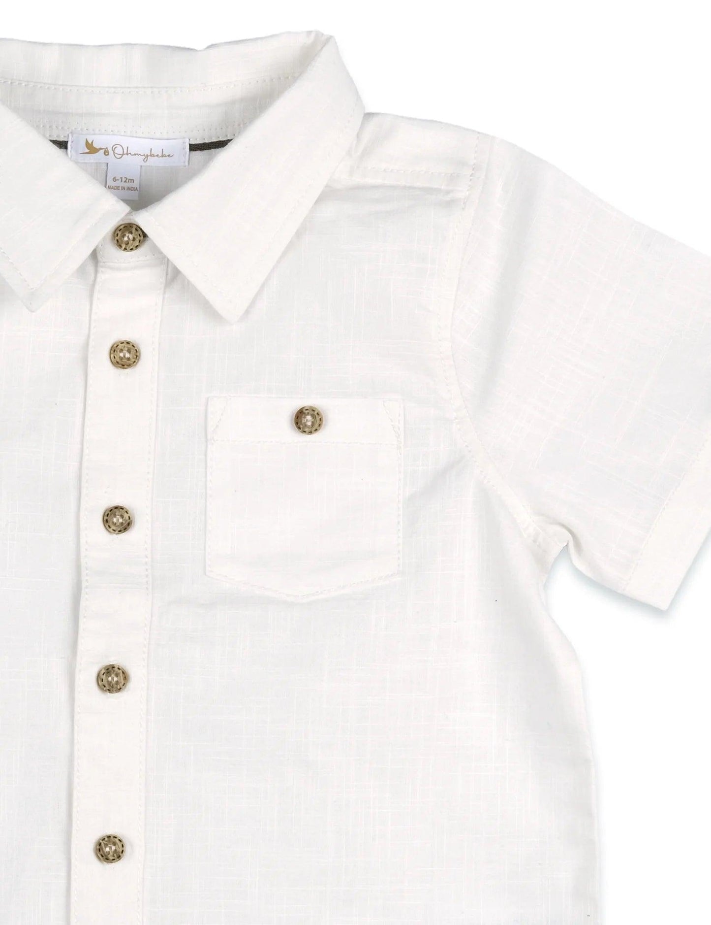 Close-up of white organic cotton toddler shirt with short sleeves, buttons, and chest pocket