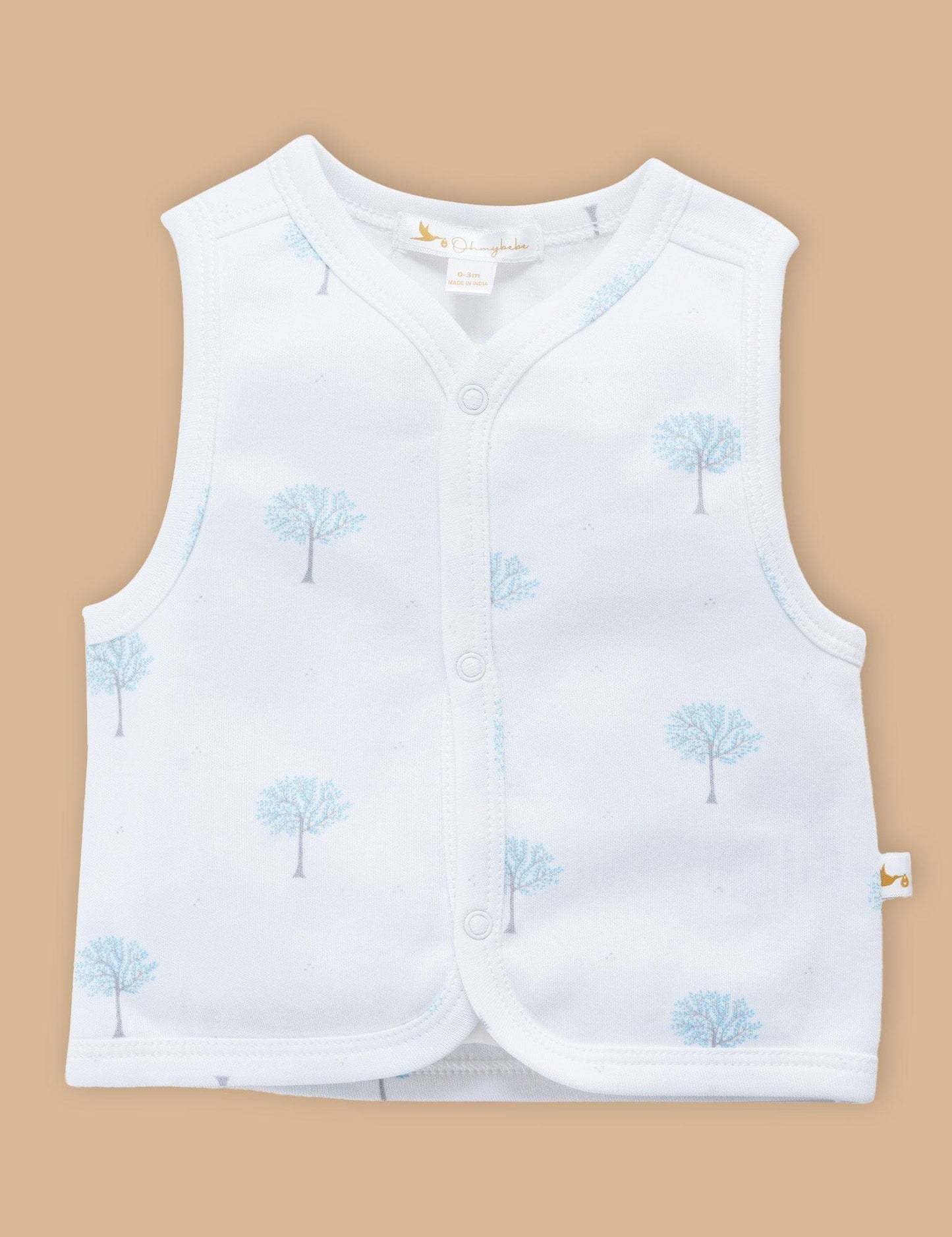 White sleeveless baby top with blue winter tree print, front snap buttons, organic cotton