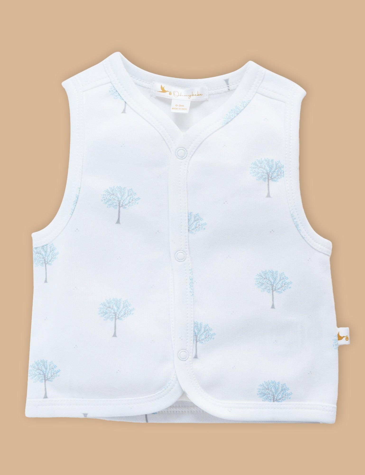 White sleeveless baby top with blue winter tree print, front snap buttons, organic cotton