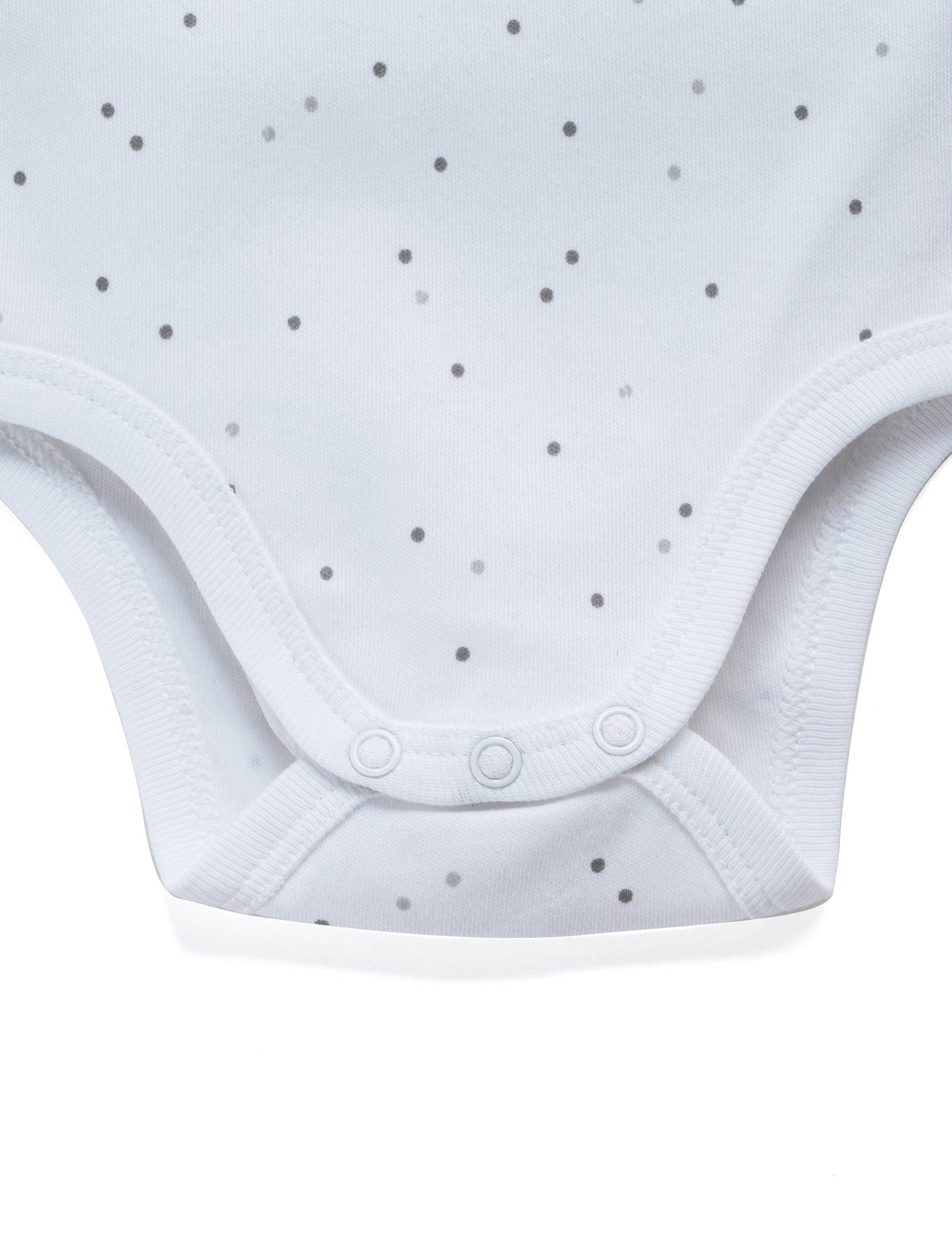 Close-up of white organic cotton baby bodysuit with grey polka dots and snap buttons