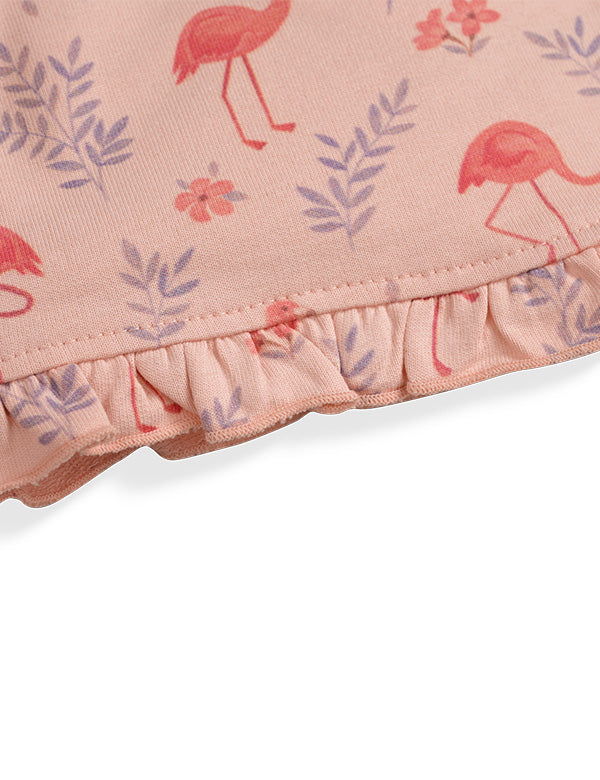 Close-up of pink fabric with red flamingo and purple leaf pattern, featuring ruffled edge detail