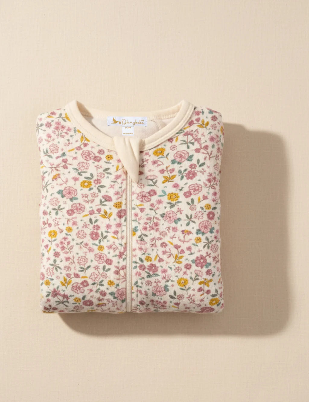 Floral-patterned baby jacket on a beige background