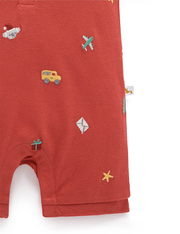 Red baby romper with embroidered designs on a white background