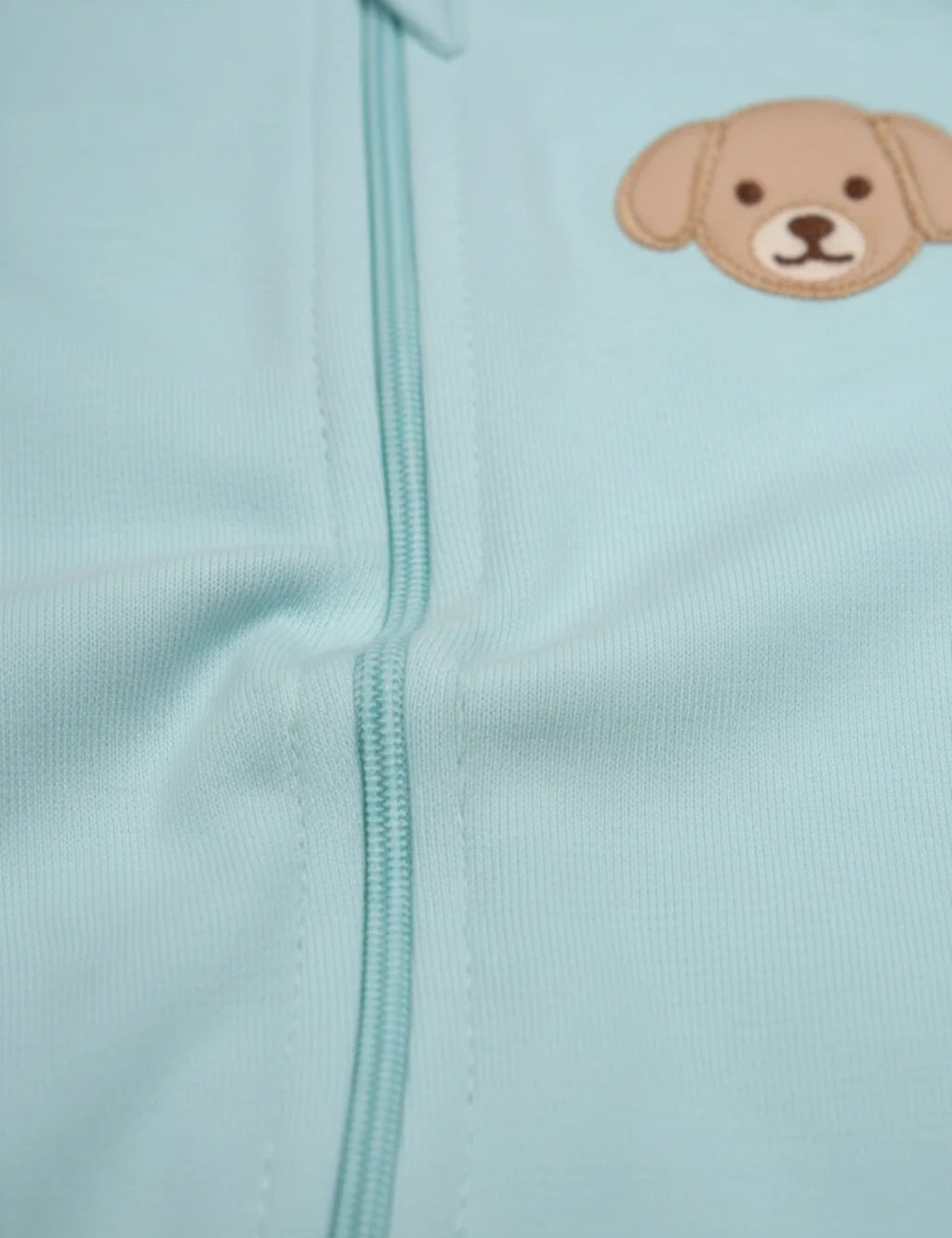 Light blue fabric with a dog face patch on a light blue background