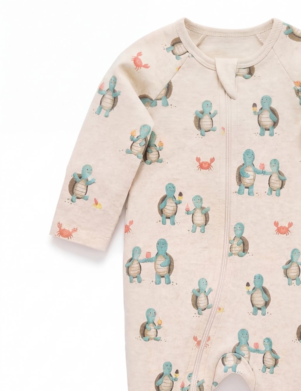 Sleeve detail of a beige organic cotton baby romper showcasing the cute hungry turtle pattern.