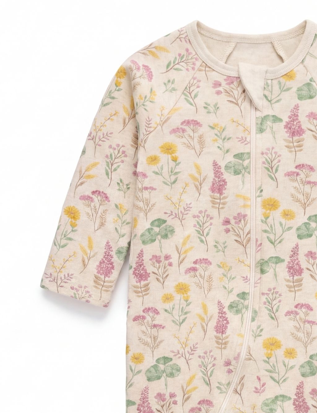 Sleeve and chest detail of a cream organic cotton baby romper with a lilypad print.