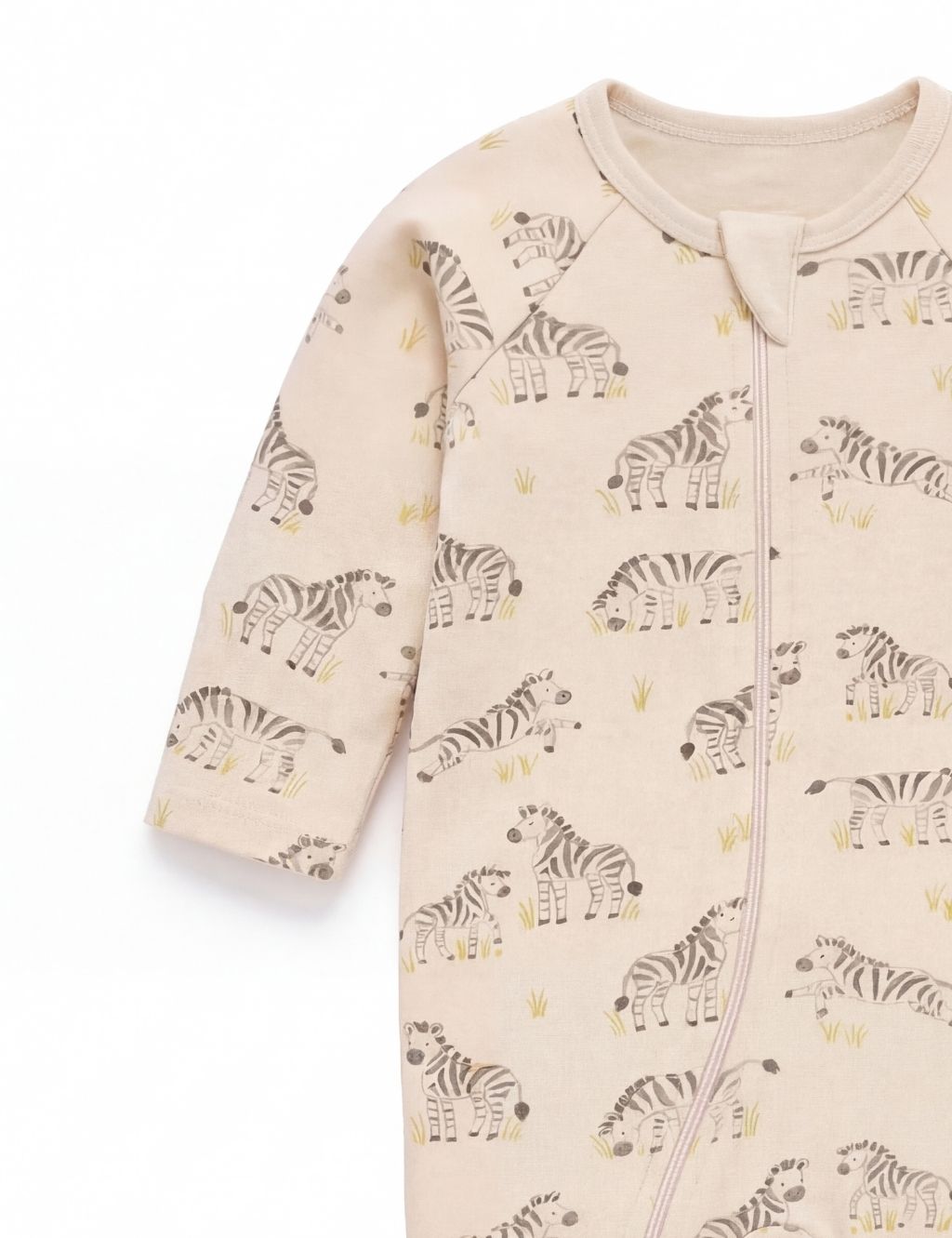 Sleeve and chest detail of an organic cotton baby romper showcasing the grazing zebra pattern.