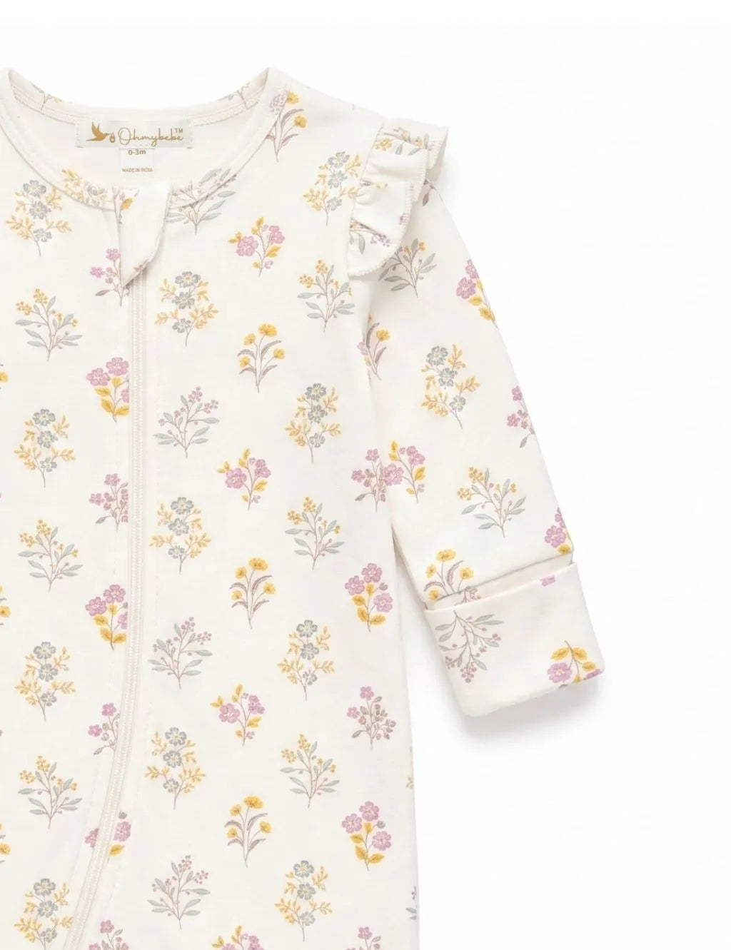 Close-up sleeve and shoulder detail of an organic cotton floral print romper showing the ruffle accent and botanical pattern.