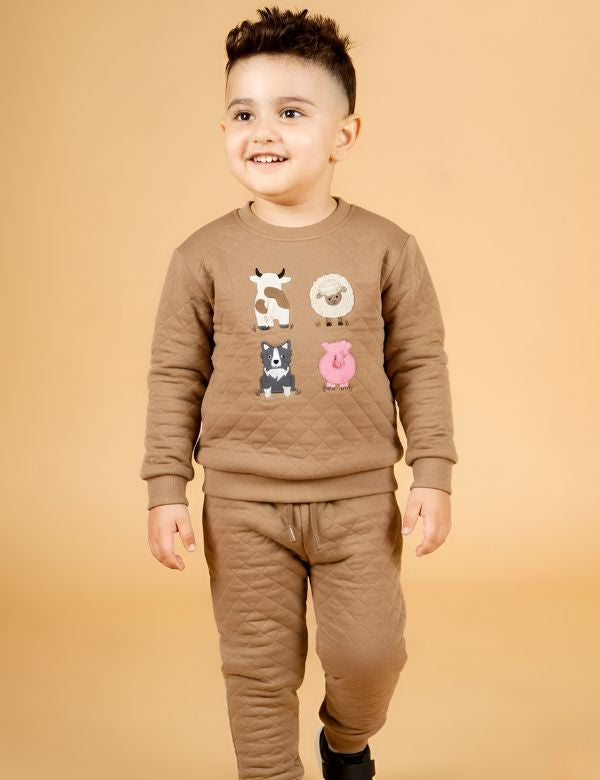 Child wearing a brown outfit with animal illustrations on a beige background