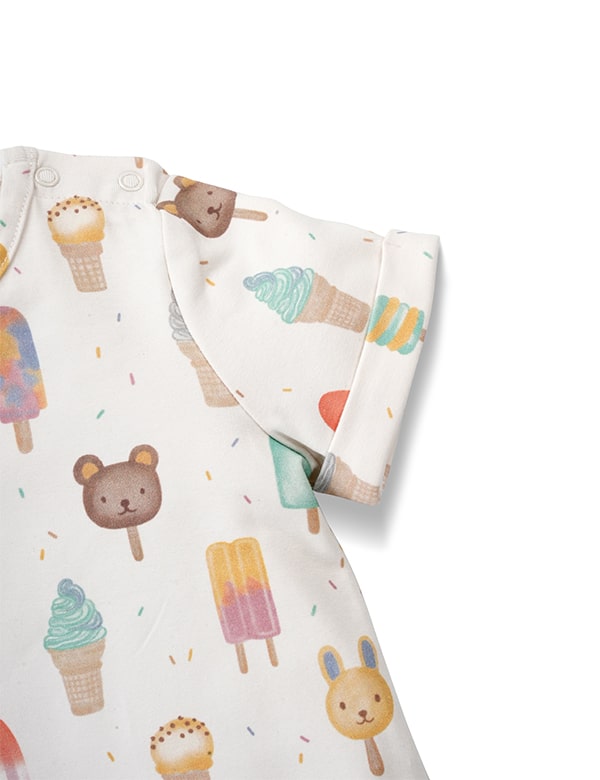 Close-up of white baby romper with colorful ice cream and animal popsicle prints, short sleeves