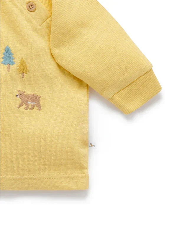Yellow baby sweatshirt with embroidered bear and colorful tree details, ribbed cuff sleeve